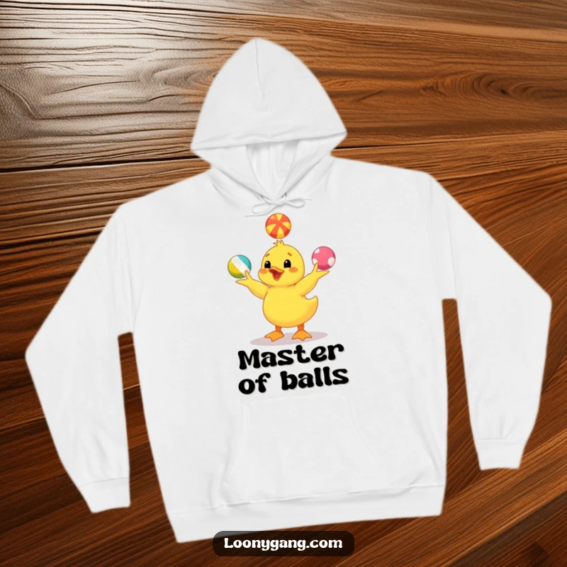 Funny yellow duckling hoodie showing a cute duckling juggling vibrant balls, offering warmth and a touch of playful humor. A cozy gift.