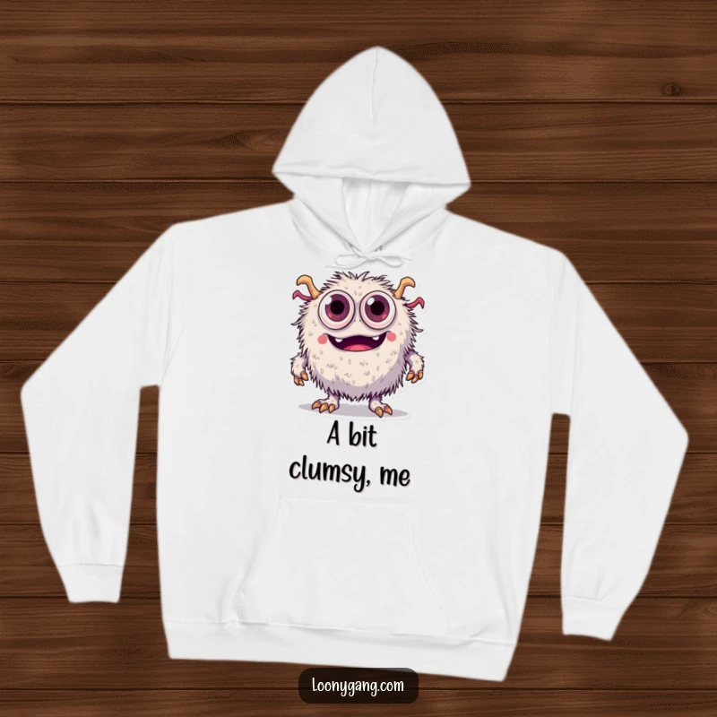 Funny fuzzy monster with an abundance of eyes tripping over its feet, featured on a soft and humorous hoodie.