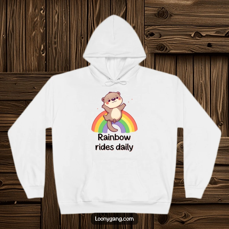 Funny otter hoodie with a playful otter sliding down a rainbow, perfect for cozying up joyfully.