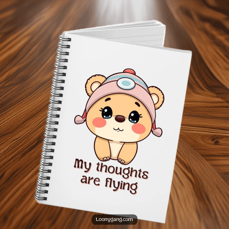 Funny bear cub wearing a propeller beanie, mid-surprise, featured on the cover of a lined notebook.