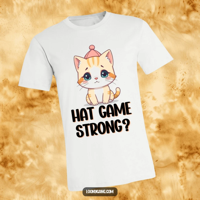 A comical illustration of a small, fluffy cat cub wearing a tiny hat tilted backward, with a bewildered expression on a t-shirt.