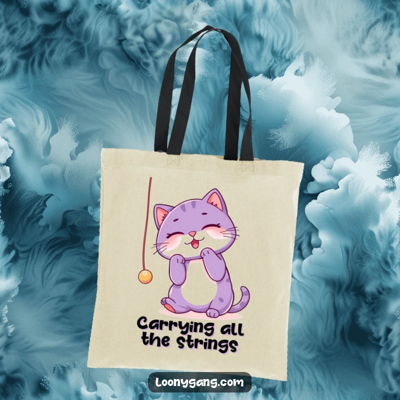 Funny purple cat tote bag capturing a playful cat batting at a string, showcasing its mischievous and energetic nature. A humorous accessory.